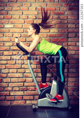 Active woman using exercise bike at the gym. Active woman using exercise bike at the gym. 22207163