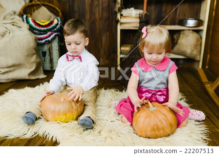 Boy and girl sitting with pumpkin 22207513