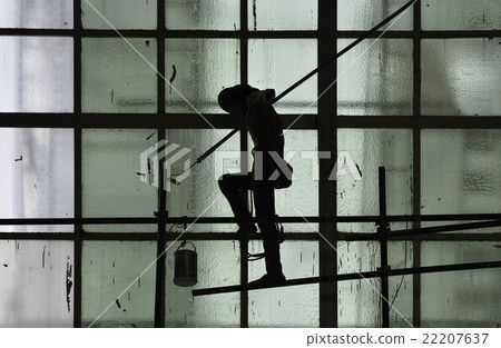 Silhouette of man painting on wall with roller 22207637