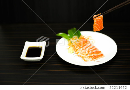 Chopsticks with sliced raw salmon lisolated 22211652