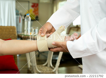 Doctor bandaging  patient is hand injuries 22211792
