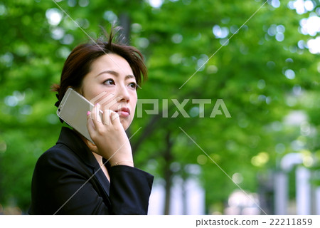 Working woman Talking in the form of a suit under the fresh green Working woman Talking in the form of a suit under the fresh green 22211859