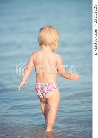 Cute baby playing on the sandy beach and in sea Cute baby playing on the sandy beach and in sea 22212228
