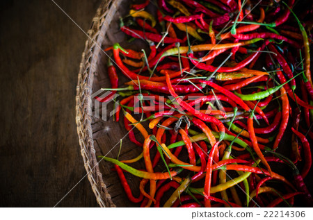 Several red and green hot chili peppers in basket 22214306