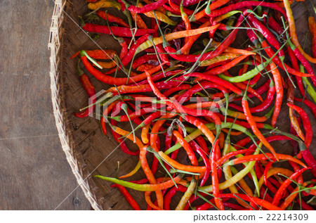 Several red and green hot chili peppers in basket 22214309