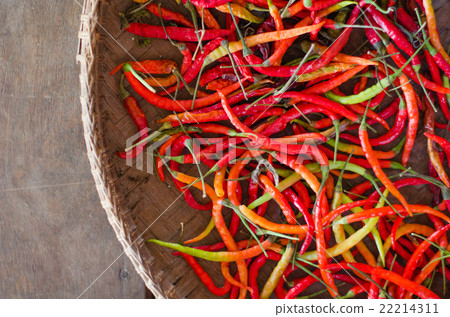 Several red and green hot chili peppers in basket 22214311