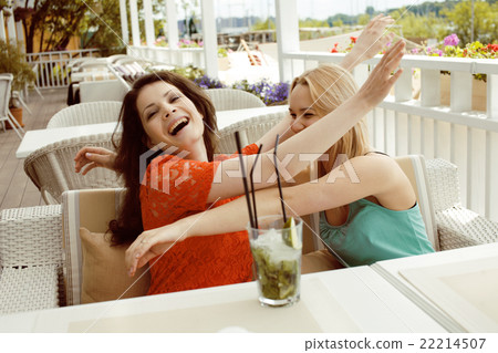 portrait of two pretty modern girl friends in cafe 22214507