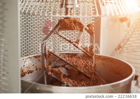Industrial mixer with brown dough. 22216638