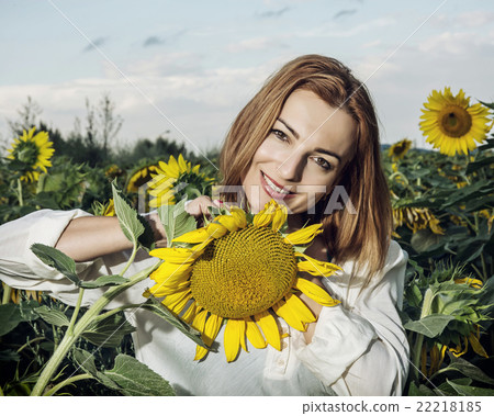 Beautiful woman posing in sunflower field, beauty and nature 22218185