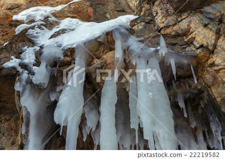 Huge icicles on a cliff. 22219582