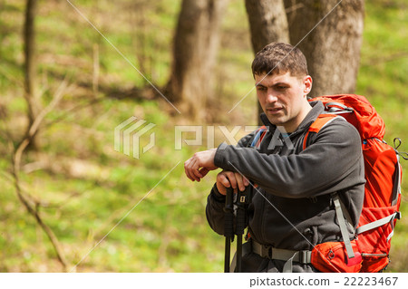 Male hiker looking to the side walking in forest 22223467