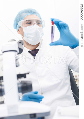 Cheerful male researcher is working in laboratory Cheerful male researcher is working in laboratory 22229558