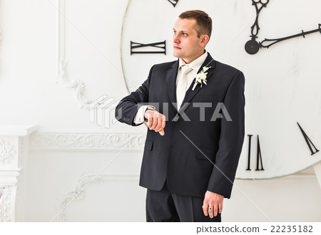 Man in black suit with big clock on background Man in black suit with big clock on background 22235182