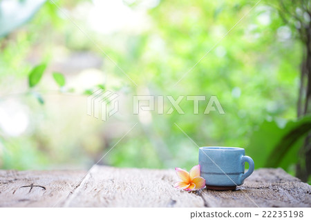 blue vintage cup and plumaria flower on wood table blue vintage cup and plumaria flower on wood table 22235198