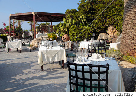 Tables and iron chairs in beautiful garden, Greece 22238220