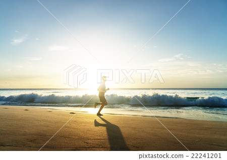 Man running on tropical beach at sunset Man running on tropical beach at sunset 22241201