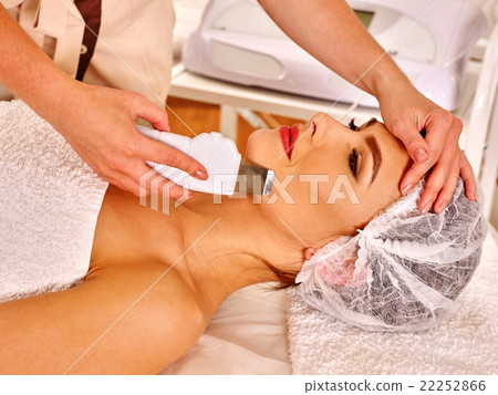 Woman receiving electric facial peeling massage. 22252866