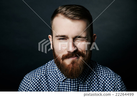 Winking red bearded man studio portrait on dark Winking red bearded man studio portrait on dark 22264499