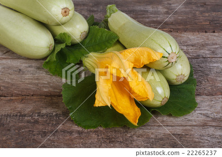 Fresh zucchini with leaves and flowers on a wooden Fresh zucchini with leaves and flowers on a wooden 22265237