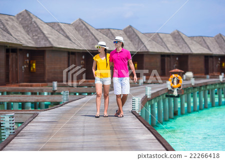 Happy couple on tropical beach jetty going to the 22266418