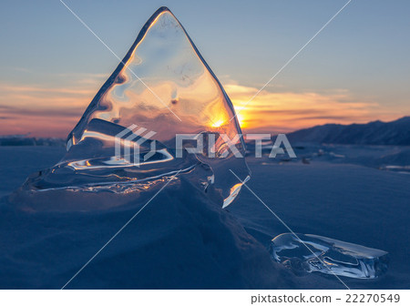 Transparent ice on sunset sky background. 22270549