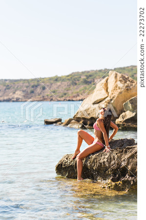 Young sexy woman relaxing on a beach near blue Young sexy woman relaxing on a beach near blue 22273702