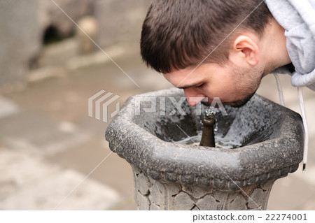 Man drinking water from fountain Man drinking water from fountain 22274001