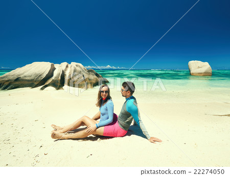 Couple at tropical beach wearing rash guard 22274050
