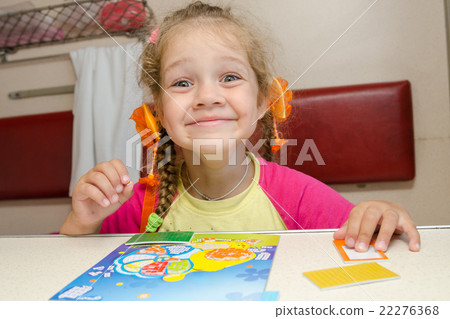 Little girl on the train with a happy smile sitting at a table on the lower second-class place car 22276368