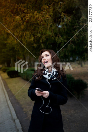 Beautiful girl listens to music in the park 22277729