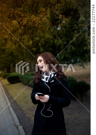 Beautiful girl listens to music in the park Beautiful girl listens to music in the park 22277744