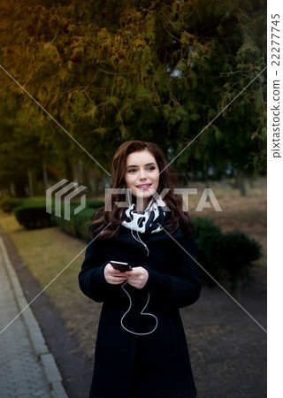 Beautiful girl listens to music in the park Beautiful girl listens to music in the park 22277745