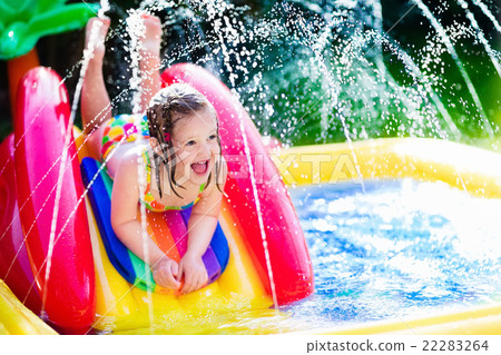 Stock Photo: Little girl in inflatable garden swimming pool