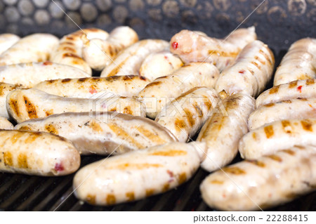 cooking sausages on a grill in the restaurant 22288415