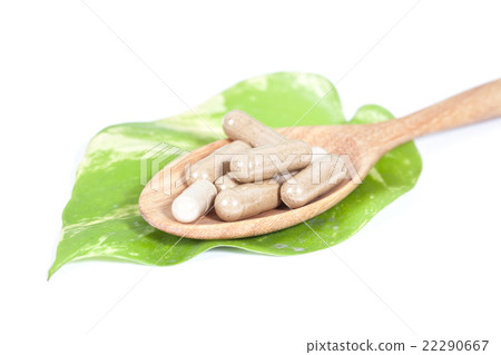 Capsules of herbs on spoon on white background Capsules of herbs on spoon on white background 22290667
