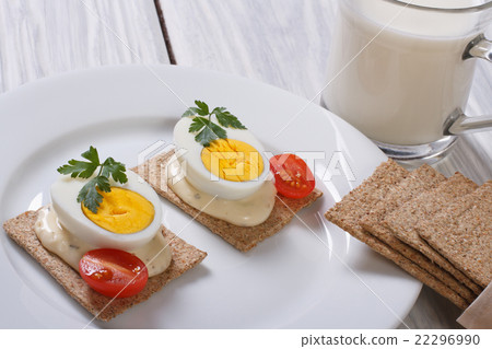 Cracker with a boiled egg, sauce and cherry tomato 22296990