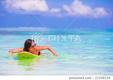 Beautiful fitness surfer woman surfing during 22298159