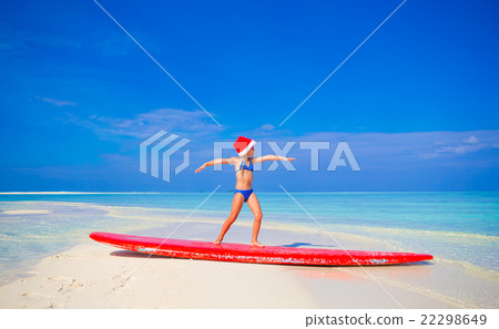 Adorable little girl in Santa hat practice surfing 22298649