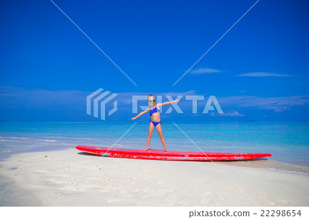 Little adorable girl on a surfboard in the Little adorable girl on a surfboard in the 22298654