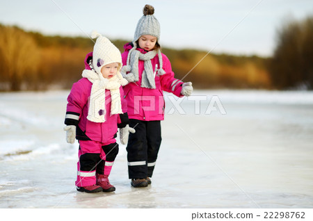Two little sisters having fun on snowy winter day 22298762
