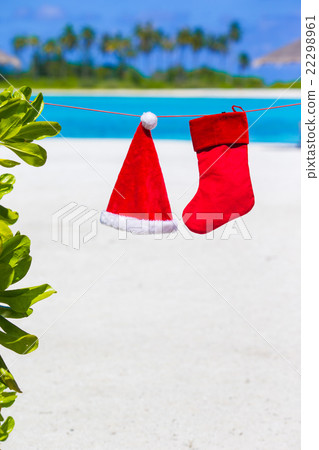 Red Santa hat and Christmas stocking hanging on Red Santa hat and Christmas stocking hanging on 22298961