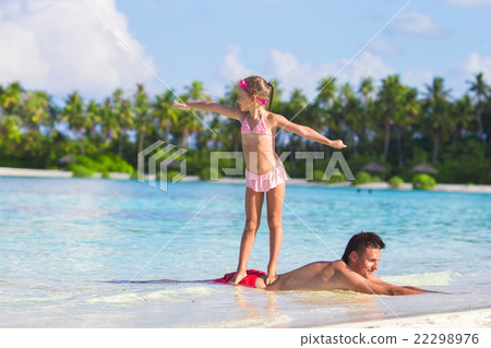 Little girl at beach practicing surfing position Little girl at beach practicing surfing position 22298976