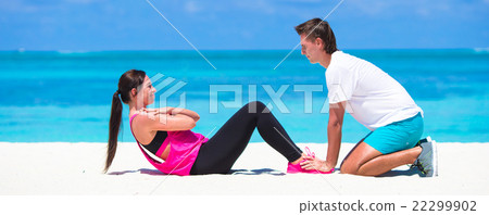 Young fitness couple doing side crunches on white Young fitness couple doing side crunches on white 22299902