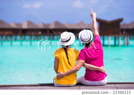Young couple on beach jetty near water villa in 22300115