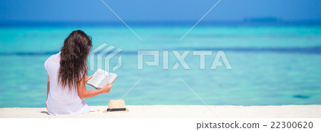 Young woman reading on tropical white beach 22300620