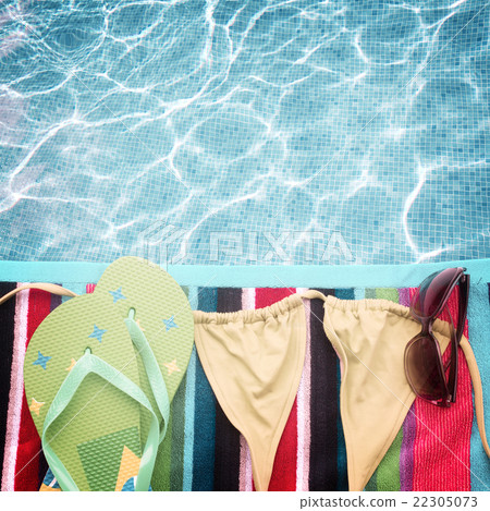 sandals and swimming suit on towel 22305073