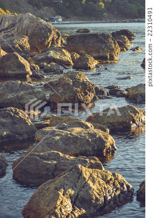 Large stones in the water near the shore 22310491