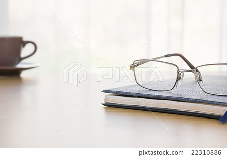 Glasses and a book on the desk 22310886
