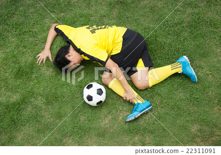 Football player lying injured on the pitch. 22311091