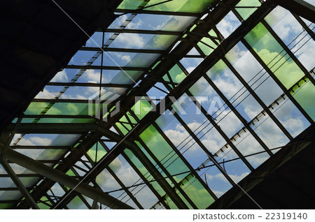 Green glass roof detail of train station over sky Green glass roof detail of train station over sky 22319140
